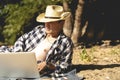 Young handsome attractive man sitting on the sandy tropical exotic beach on a summer resort working on a laptop Royalty Free Stock Photo