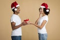 Young handsome bearded african american man gives to woman Christmas present Royalty Free Stock Photo