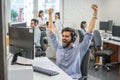 Young handsome bearded businessman celebrating corporate success with his fists raised in the air Royalty Free Stock Photo