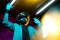 Young handsome bearded hipster man with curly hair wearing virtual reality goggles in motion in neon lights. Smartphone