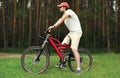 Young handsome bearded man sitting on a bicycle in the forest