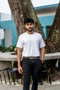 A young handsome bearded man wearing a blank white shirt doing a pose outdoor Royalty Free Stock Photo