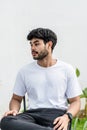 A young handsome bearded man wearing a blank white shirt doing a pose outdoor Royalty Free Stock Photo