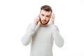 Young handsome man tired of talking on the phone. Casual man feeling headache while talking on the phone isolated Royalty Free Stock Photo