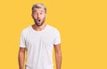 Young handsome blond man wearing casual t-shirt afraid and shocked with surprise expression, fear and excited face Royalty Free Stock Photo