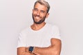 Young handsome blond man wearing casual t-shirt standing over isolated white background happy face smiling with crossed arms Royalty Free Stock Photo