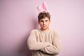 Young handsome blond man wearing easter rabbit ears over isolated pink background skeptic and nervous, disapproving expression on Royalty Free Stock Photo
