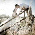 Young handsome bridal couple kissing through the long grass