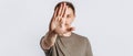 Young handsome brunette man with beard stretched out his hand forward and says STOP on white isolated background Royalty Free Stock Photo