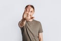 Young handsome brunette man with beard stretched out his hand forward and says STOP on white isolated background Royalty Free Stock Photo