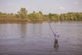 Young handsome brutal caucasian man in casual outfit fishing on Royalty Free Stock Photo