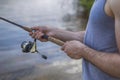 Young handsome brutal caucasian man in casual outfit fishing on Royalty Free Stock Photo