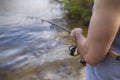 Young handsome brutal caucasian man in casual outfit fishing on Royalty Free Stock Photo