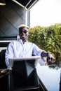 Young handsome business african young man using tablet in outdoor cafe terrace Royalty Free Stock Photo