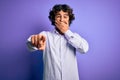 Young handsome business man with beard wearing shirt standing over purple background laughing at you, pointing finger to the Royalty Free Stock Photo