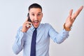 Young handsome business man calling using smartphone over isolated background very happy and excited, winner expression Royalty Free Stock Photo