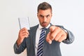 Young handsome business man holding blank notebook over isolated background pointing with finger to the camera and to you, hand Royalty Free Stock Photo