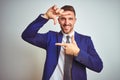 Young handsome business man over white isolated background smiling making frame with hands and fingers with happy face Royalty Free Stock Photo