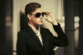 Young handsome business man in sunglasses standing at the wall Royalty Free Stock Photo