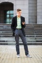 Young handsome business man using cell phone on city street Royalty Free Stock Photo
