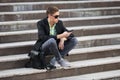 Young handsome business man using cell phone sitting on steps Royalty Free Stock Photo