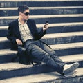 Young handsome business man using smart phone on steps Royalty Free Stock Photo