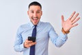 Young handsome business man using smartphone over isolated background very happy and excited, winner expression celebrating Royalty Free Stock Photo