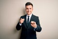 Young handsome business man wearing elegant suit and tie over isolated background pointing fingers to camera with happy and funny Royalty Free Stock Photo