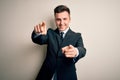 Young handsome business man wearing elegant suit and tie over isolated background pointing to you and the camera with fingers, Royalty Free Stock Photo