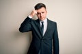 Young handsome business man wearing elegant suit and tie over isolated background pointing unhappy to pimple on forehead, ugly Royalty Free Stock Photo