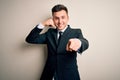 Young handsome business man wearing elegant suit and tie over isolated background smiling doing talking on the telephone gesture Royalty Free Stock Photo