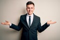 Young handsome business man wearing elegant suit and tie over isolated background smiling showing both hands open palms, Royalty Free Stock Photo