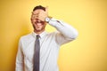 Young handsome business man wearing elegant white shirt over yellow isolated background smiling and laughing with hand on face Royalty Free Stock Photo