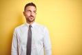 Young handsome business man wearing elegant white shirt over yellow isolated background smiling looking to the side and staring Royalty Free Stock Photo