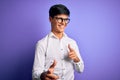 Young handsome business man wearing shirt and glasses over isolated purple background pointing fingers to camera with happy and Royalty Free Stock Photo