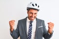 Young handsome business man wearing suit and tie and bike helmet over isolated background very happy and excited doing winner Royalty Free Stock Photo