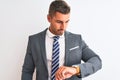 Young handsome business man wearing suit and tie over isolated background Checking the time on wrist watch, relaxed and confident Royalty Free Stock Photo