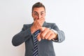 Young handsome business man wearing suit and tie over isolated background laughing at you, pointing finger to the camera with hand Royalty Free Stock Photo