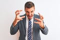 Young handsome business man wearing suit and tie over isolated background Shouting frustrated with rage, hands trying to strangle, Royalty Free Stock Photo