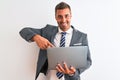 Young handsome business man working using computer laptop over isolated background very happy pointing with hand and finger Royalty Free Stock Photo