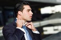 Young handsome businessman adjusting a tie in urban background Royalty Free Stock Photo