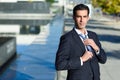 Young handsome businessman adjusting a tie in urban background Royalty Free Stock Photo