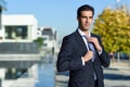 Young handsome businessman adjusting a tie in urban background Royalty Free Stock Photo