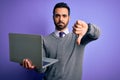 Young handsome businessman with beard working using laptop over purple background with angry face, negative sign showing dislike Royalty Free Stock Photo