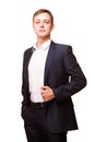 Young handsome businessman in black suit is standing straight and putting his hands in pockets, portrait isolated on Royalty Free Stock Photo