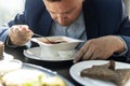 a man in a jacket is having lunch at a black table. Lunch break. Young handsome businessman eating lunch in a cafe Royalty Free Stock Photo