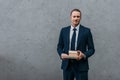 young handsome businessman holding stack of books in front of