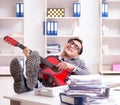 Young handsome businessman playing guitar in the office Royalty Free Stock Photo