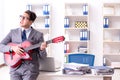 The young handsome businessman playing guitar in the office Royalty Free Stock Photo