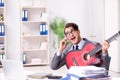 The young handsome businessman playing guitar in the office Royalty Free Stock Photo